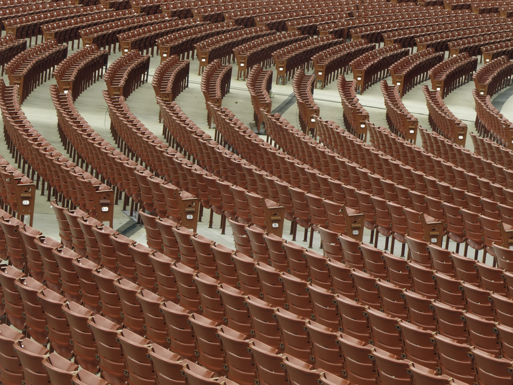Symmetry of festival seats curved rows of identical red fixed seats for audience of  thousands