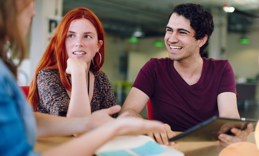 Unposed group of creative business people in an open concept office brainstorming their next project.